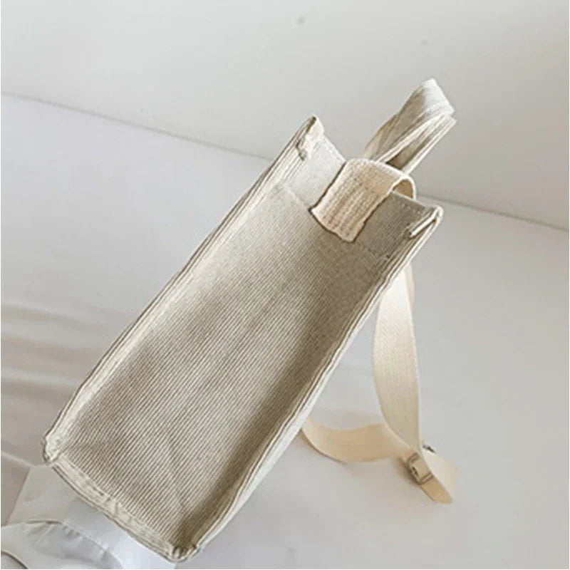 Beige handbag with a strap on a white background