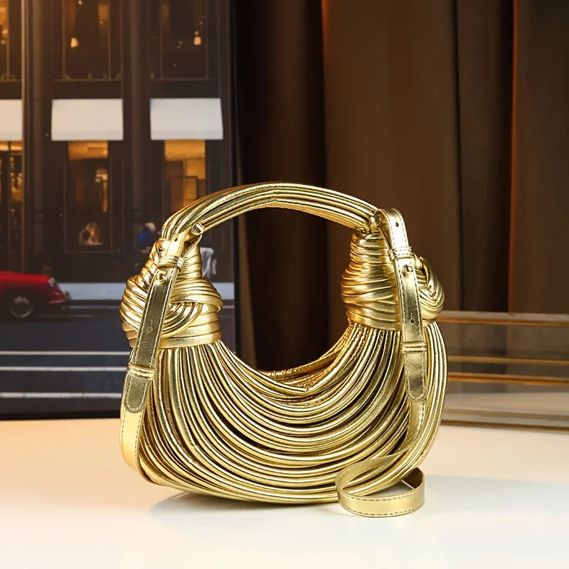 Gold handbag on a reflective surface with a blurred background
