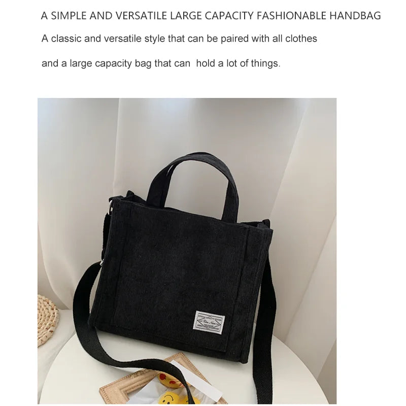Black handbag with a strap on a white surface, text describing its features.